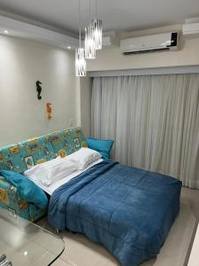 a bedroom with a large blue bed and a chandelier at Gavoa Resort Flat - Mar Doce Lar in Igarassu +14 photos