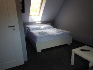 a small bedroom with a bed with a window at Willa Marion in Karpacz