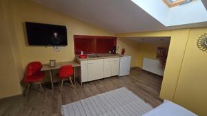 a kitchen with a table and a tv on the wall at City Center Stay Apartament cu Parcare Modern & Liniștit in Iaşi