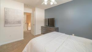 una camera bianca con letto e TV a schermo piatto di Landing - Modern Apartment with Amazing Amenities (ID7689X22) a Spring Hill