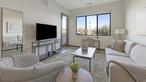 sala de estar con 2 sofás y TV de pantalla plana en Landing - Modern Apartment with Amazing Amenities (ID9728X49), en Scottsdale