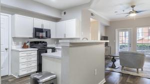 une cuisine avec des placards blancs et un comptoir dans l'établissement Landing - Modern Apartment with Amazing Amenities (ID9398X92), à Lewisville