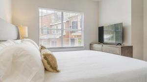 - une chambre blanche avec un grand lit et une fenêtre dans l'établissement Landing - Modern Apartment with Amazing Amenities (ID9398X92), à Lewisville