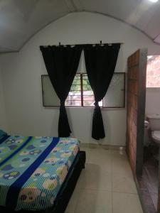 1 dormitorio con cama, lavabo y ventana en Casa de relajación low cost, en La Dorada