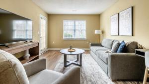 sala de estar con sofá y TV en Landing - Modern Apartment with Amazing Amenities (ID7932X45), en Holly Springs