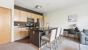 a kitchen with a counter and chairs in a room at Landing - Modern Apartment with Amazing Amenities (ID9415X89) in Milwaukee