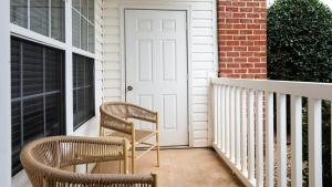 dos sillas sentadas en el porche de una casa en Landing - Modern Apartment with Amazing Amenities (ID7932X45), en Holly Springs