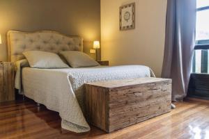 a bedroom with a large bed with a wooden trunk at Hotel Montañas de Covadonga in Cangas de Onís