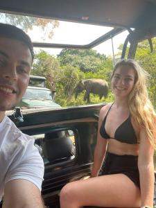 Ein Mann und eine Frau sitzen hinten im Auto mit einem Elefanten. in der Unterkunft Yala Leisure Villa & Safari in Tissamaharama