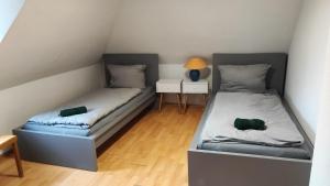 two beds in a small room with a night stand at Monteurwohnung bis zu 10 Personen mit 5 großen gratis Parkplätzen und WLAN in Veitshöchheim