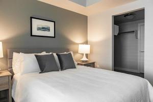 1 dormitorio con 1 cama blanca grande y 2 lámparas en Landing - Modern Apartment with Amazing Amenities (ID2762X29), en Murray