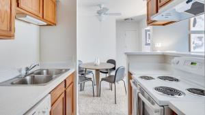 una cucina con lavandino e tavolo con sedie di Landing - Modern Apartment with Amazing Amenities (ID7851X76) a Buffalo Grove