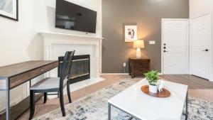 un soggiorno con tavolo e camino di Landing - Modern Apartment with Amazing Amenities (ID2679X34) a Fort Worth