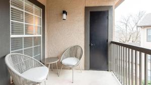 un portico con due sedie e un tavolo e una porta di Landing - Modern Apartment with Amazing Amenities (ID2679X34) a Fort Worth