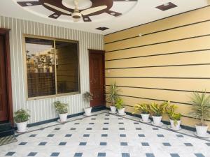 a porch with potted plants and a ceiling at Britannia House near Islamabad International Airport and Motorway in Islamabad