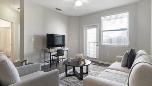 een woonkamer met een bank en een tv bij Landing - Modern Apartment with Amazing Amenities (ID1192X099) in Kissimmee