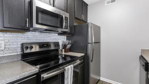 a kitchen with a stove and a microwave at Landing - Modern Apartment with Amazing Amenities (ID9303X46) in Lewis Center