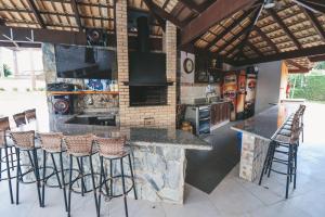 a kitchen with a bar with stools and a stove at Paraíso do Salto in Lages
