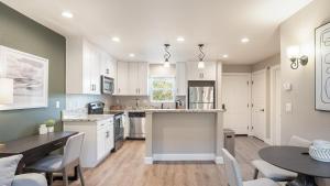 een keuken met witte kasten en een tafel en stoelen bij Landing - Modern Apartment with Amazing Amenities (ID8203X92) in Fremont