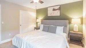 een slaapkamer met een groot wit bed met 2 lampen bij Landing - Modern Apartment with Amazing Amenities (ID8203X92) in Fremont