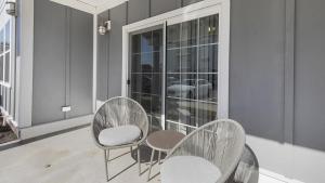 dwa krzesła i stół na balkonie w obiekcie Landing - Modern Apartment with Amazing Amenities (ID4693X56) w mieście Suffolk