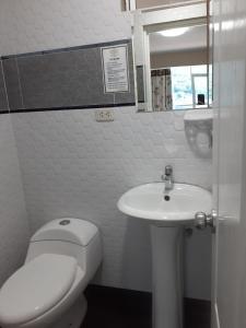 ein weißes Bad mit einem WC und einem Waschbecken in der Unterkunft HOTEL REAL PALACE CHURIN in Churín