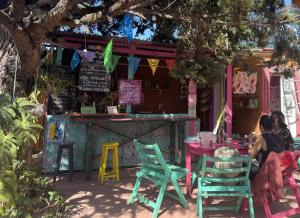 una mujer sentada en una mesa frente a un bar en Historika Hostel Cultural, en San Cristóbal de Las Casas