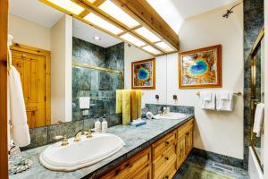 a bathroom with two sinks and a large mirror at 3137 Arrowhead in Teton Village