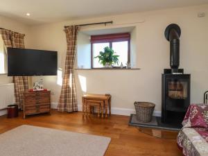 a living room with a wood stove and a tv at Hill Brook Barn in Clitheroe