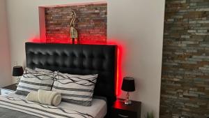 1 dormitorio con cabecero negro e iluminación roja en Alquiler de Apartamento vacacional en la Isla de Margarita, en Pampatar