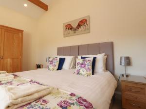 a bedroom with a bed with white sheets and pillows at Hill Brook Barn in Clitheroe