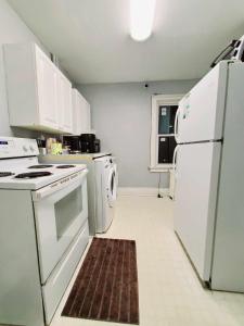 a kitchen with white appliances and a brown rug at Merj's Guest House in Wolesly in Winnipeg