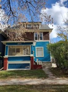 a blue house with the number on it at Merj's Guest House in Wolesly in Winnipeg