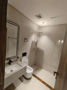 a bathroom with a sink and a toilet and a mirror at Elaf Suites Al Hamra in Jeddah