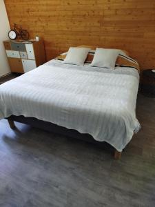 1 dormitorio con 1 cama grande y pared de madera en Le cheval blanc, en Carrouges