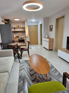 ein Wohnzimmer mit einem Sofa und einem Tisch in der Unterkunft Alex's Apartment in Durrës