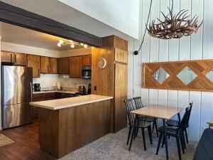 a kitchen with wooden cabinets and a table with chairs at Epic Condo walk to Canyon Lodge in Mammoth Lakes