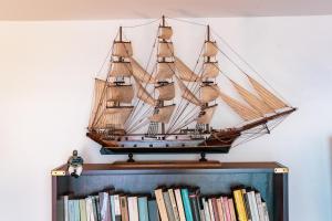 un buque modelo en la parte superior de una estantería de libros en Admiral's apartments, en Aci Catena