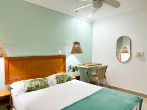 sypialnia z łóżkiem, biurkiem i lustrem w obiekcie Hotel Valladolid w mieście Santa Marta