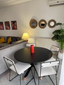 a dining room with a black table and chairs at Bel appartement à 9 min de l’aéroport in Ariana