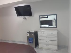 ein Schlafzimmer mit einer Kommode und einem Flachbild-TV in der Unterkunft HOTEL REAL PALACE CHURIN in Churín