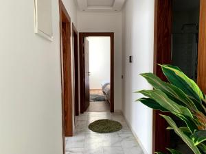 um corredor com uma porta e um vaso de plantas em Luxurious experience in apartment, Founty at Saphir Residence em Agadir