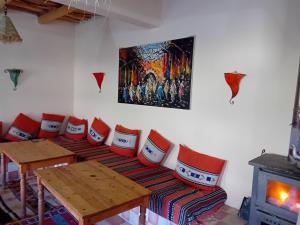 um quarto com uma mesa e cadeiras e uma lareira em Maison d'Hôtes Agdal Telouet em Tiguidert