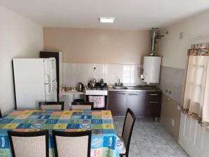 Una cocina con mesa y sillas y un refrigerador. en Lo de fernando 1, en Río Gallegos