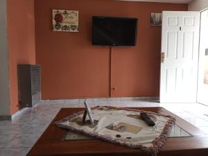 a room with a table with a tv on a wall at Lo de fernando 1 in Río Gallegos