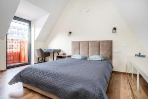 a bedroom with a bed and a desk and a window at Cozy Central Attic SELF Check In in Vilnius