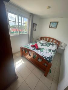 - une chambre avec un lit dans une pièce dotée d'une fenêtre dans l'établissement Chez Maïté, à Terre-de-Bas