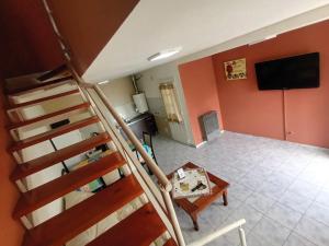 a room with a staircase and a living room with a television at Lo de fernando 1 in Río Gallegos