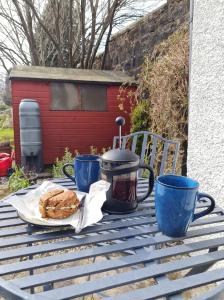 een tafel met een koffiepot en een bord eten bij The Apartment at No.12 in Lochwinnoch