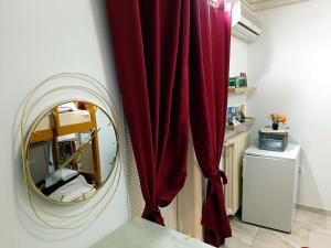Zimmer mit einem roten Vorhang und einem Spiegel in der Unterkunft Java apartments - S & J in Dobrota